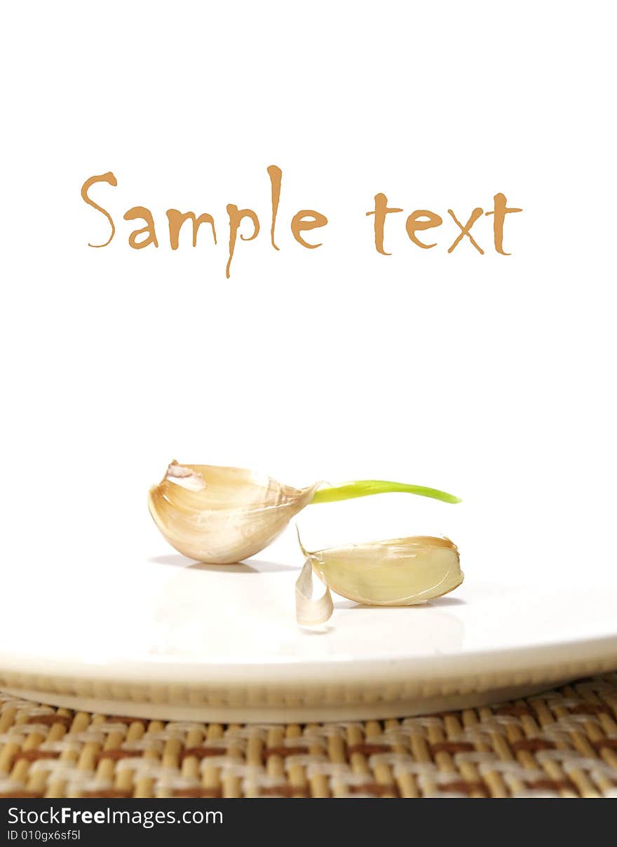 Garlic on a plate isolated on a white background. Garlic on a plate isolated on a white background