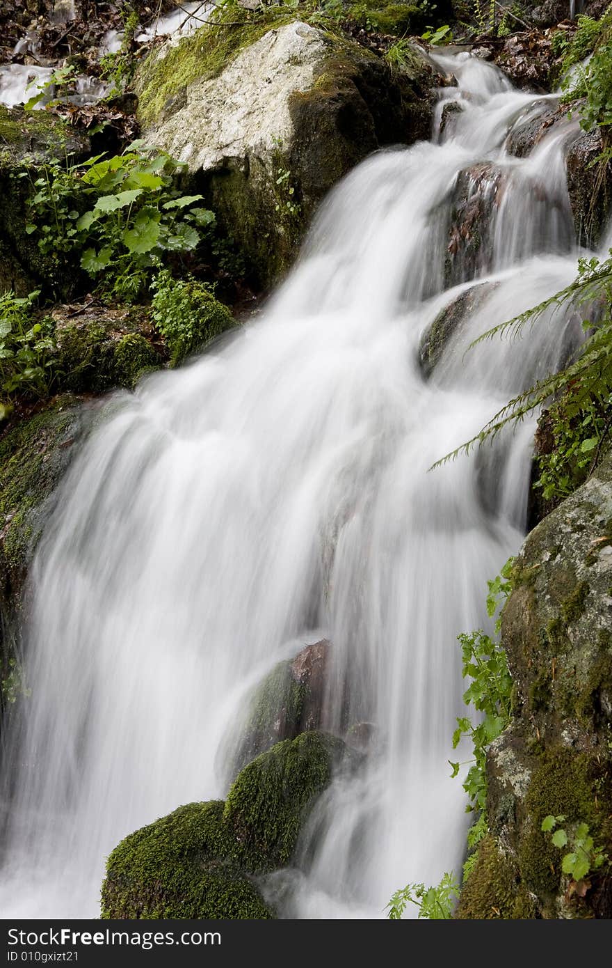 Beautiful waterfall between vegetation and stones