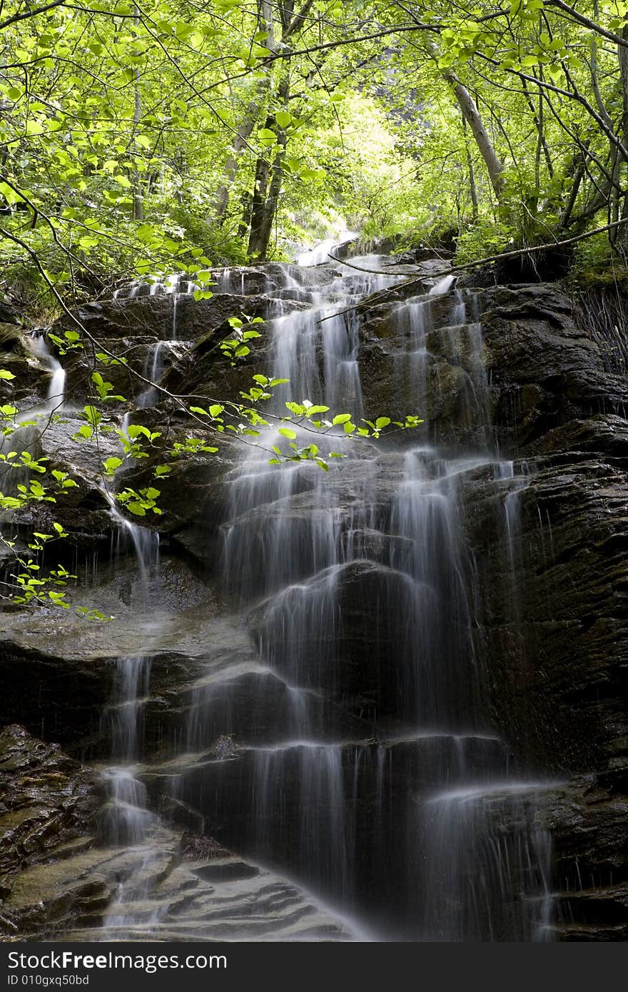 Beautiful waterfall between vegetation and stones