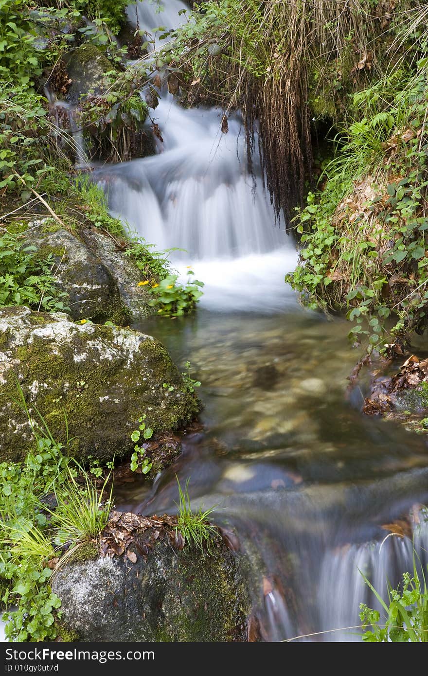 Beautiful waterfall between vegetation and stones