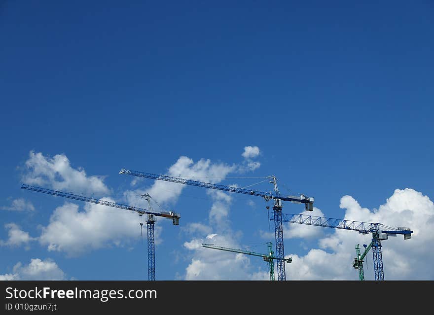 Construction cranes against nice clouds on a sky