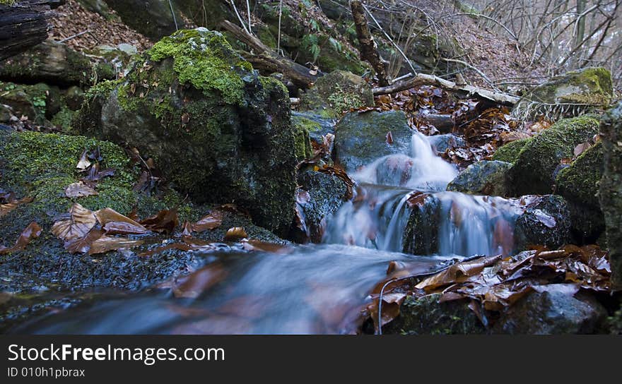 Beautiful waterfall between vegetation and stones