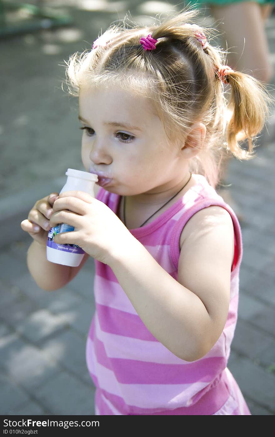 Little cute girl drinking yoghurt