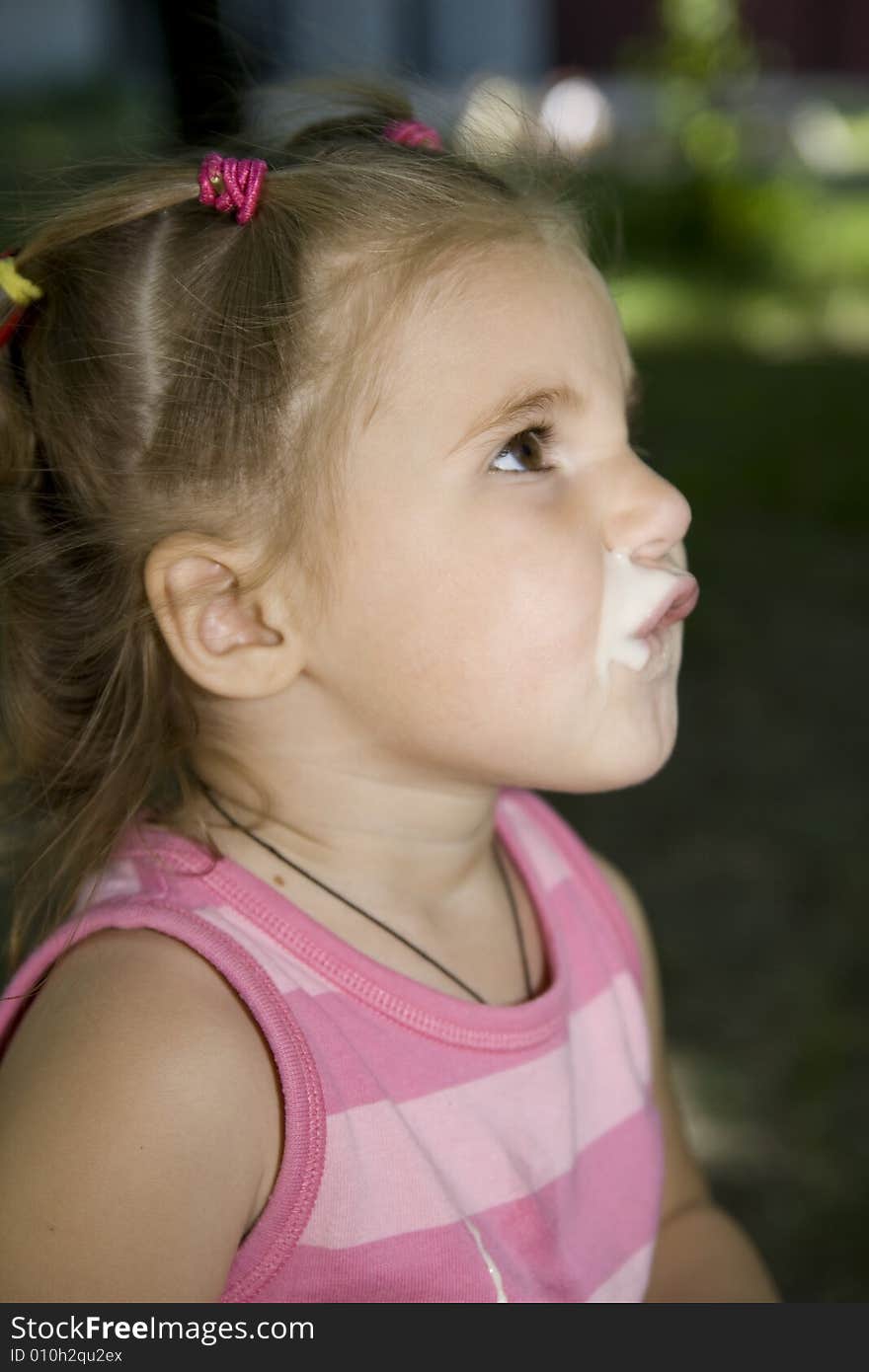 Little cute girl drinking yoghurt