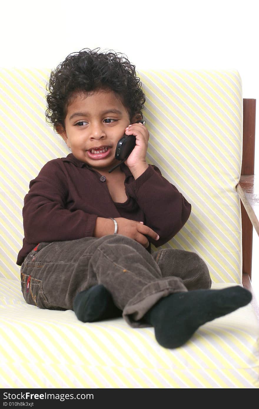 Young Asian Indian boy holding cell phone and smiling. Young Asian Indian boy holding cell phone and smiling