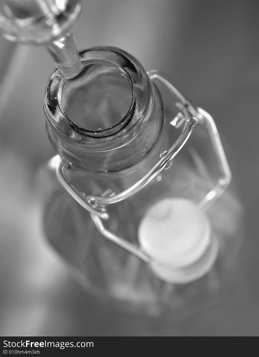 B & W (black and white) picture of water dripping into a bottle seen from above.