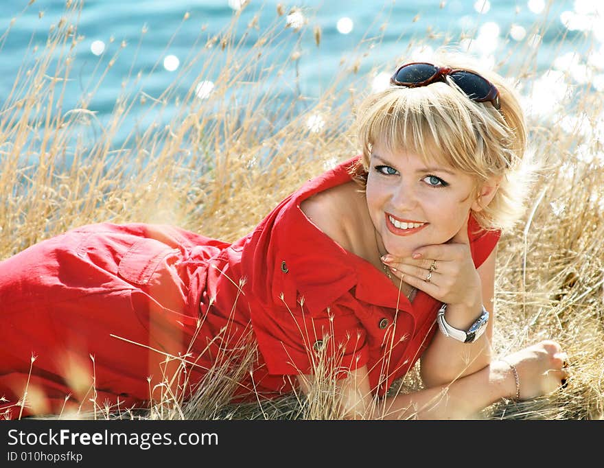 Beautiful blonde in a red dress on a sea resort. Beautiful blonde in a red dress on a sea resort