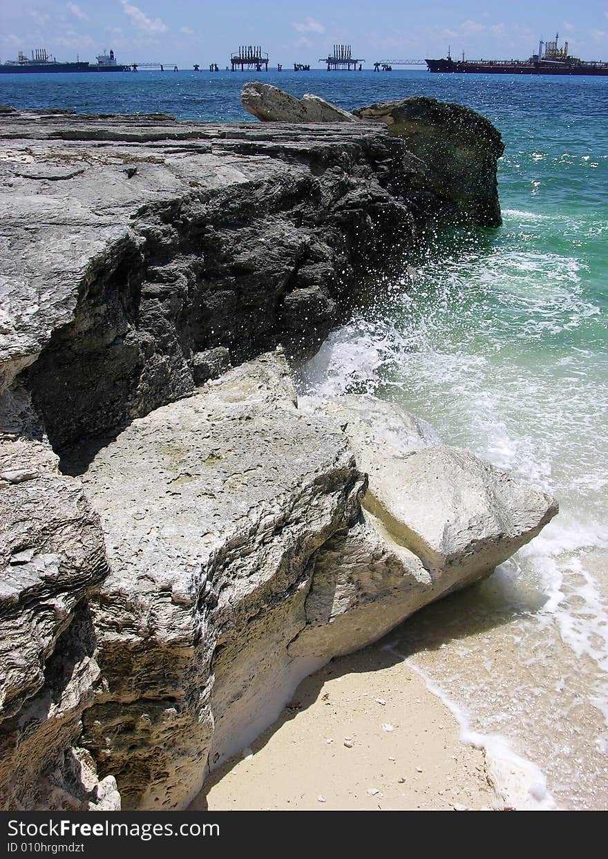 The wave splashes over eroded rocky coast in Freeport on Grand Bahama Island, The Bahamas.