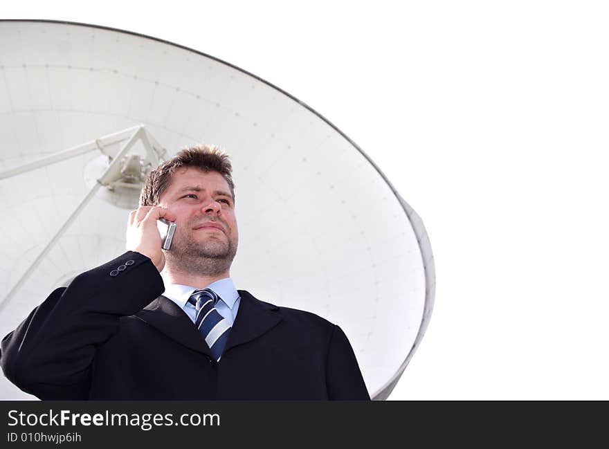 Businessman infront of big satellite dish isolated on white. Businessman infront of big satellite dish isolated on white