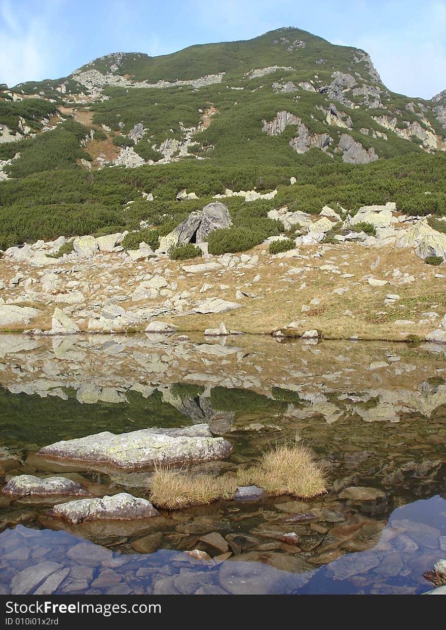 Mountain Peak Reflected In Still Lake Retezat National Park. Mountain Peak Reflected In Still Lake Retezat National Park.