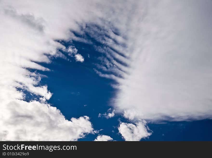 Deep blue sky clearing up between tearing apart white heavy clouds. Deep blue sky clearing up between tearing apart white heavy clouds.