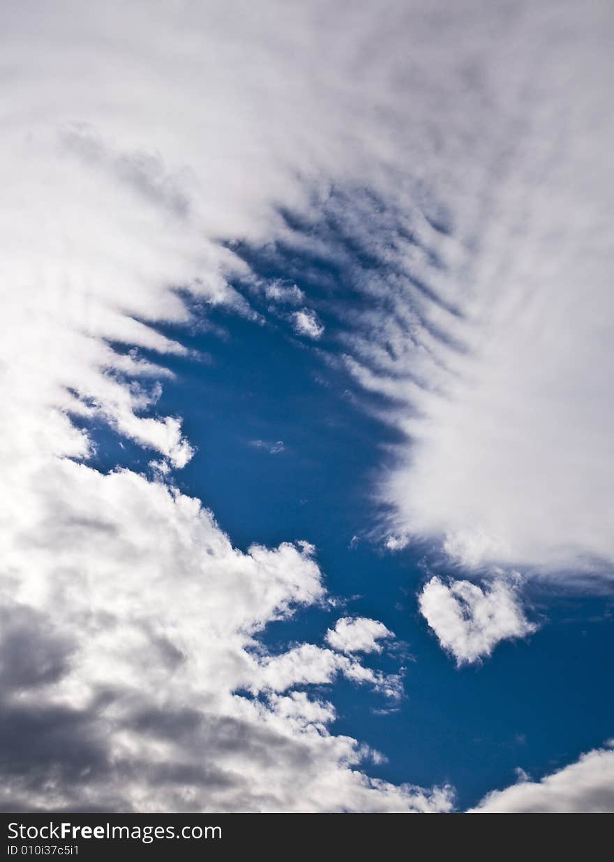 Deep blue sky clearing up between tearing apart white heavy clouds. Deep blue sky clearing up between tearing apart white heavy clouds.