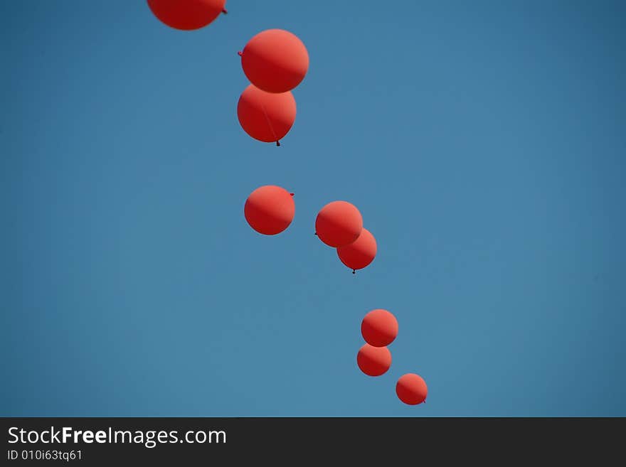 Red and blue balloons strung together against sky. Red and blue balloons strung together against sky