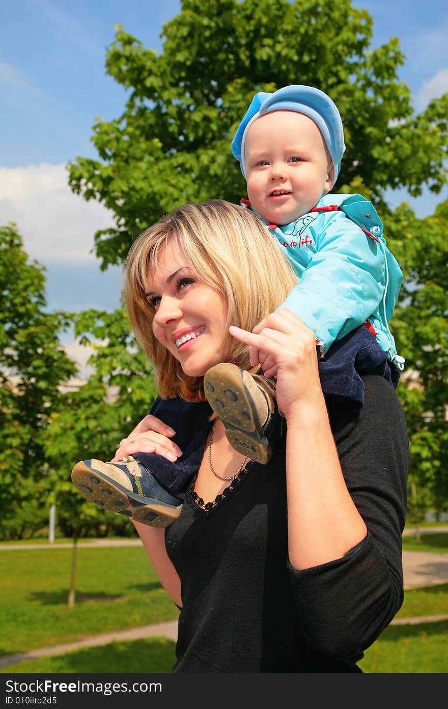 Mother with the child on shoulders outdoor