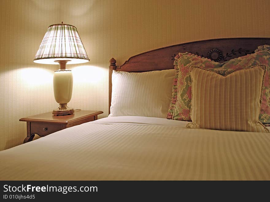 Group of several pillows on a bed with headboard. Group of several pillows on a bed with headboard