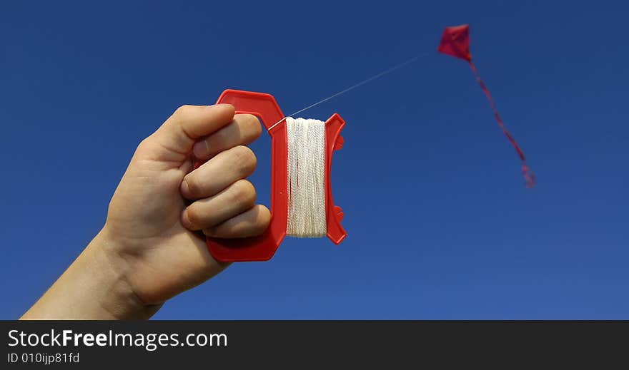 Girl flying a kite in a park with blue sky