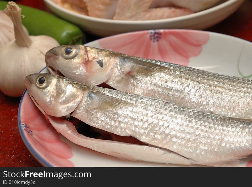 Two fishes in the dish, ready for cooking. Two fishes in the dish, ready for cooking.