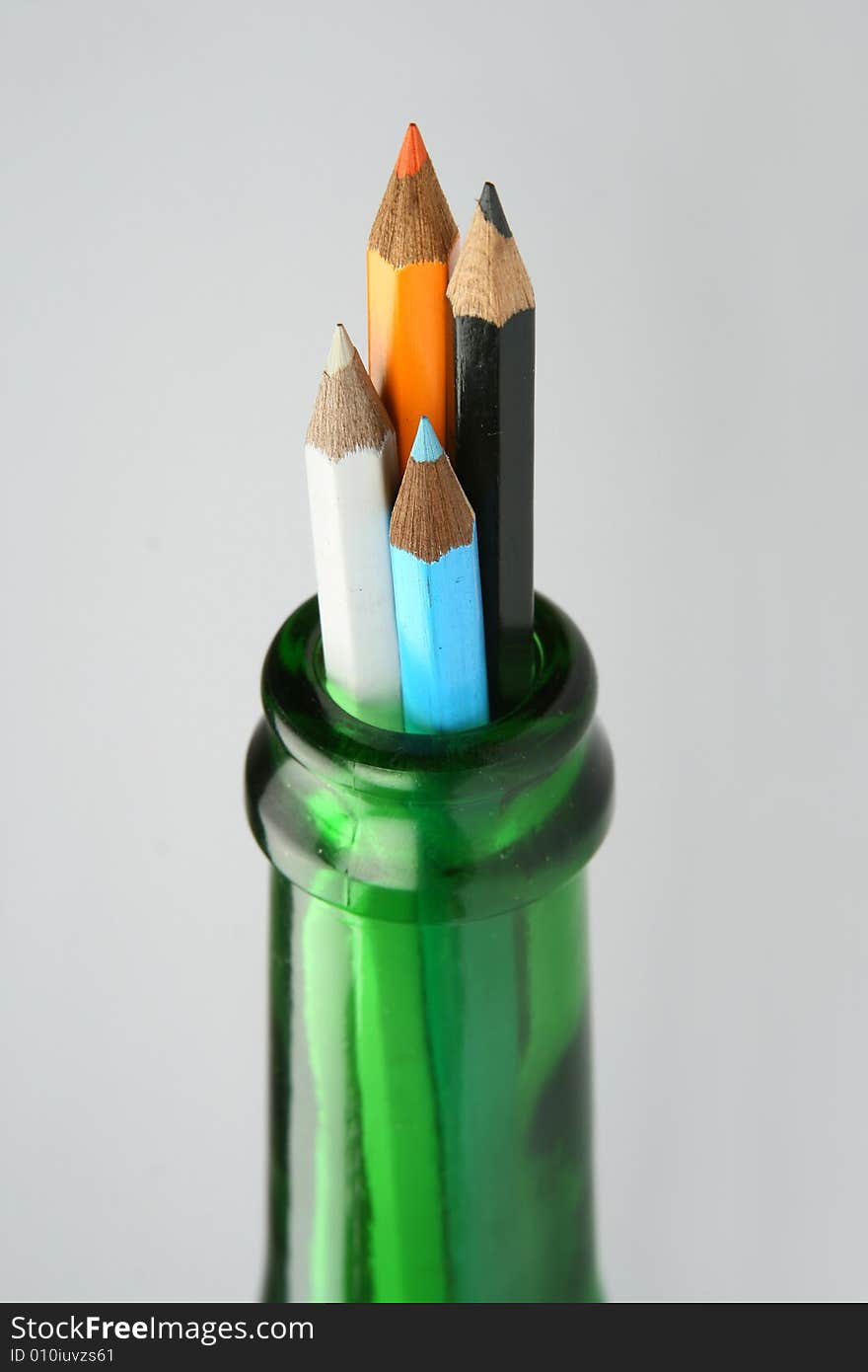 Four pencils in green bottle. Four pencils in green bottle