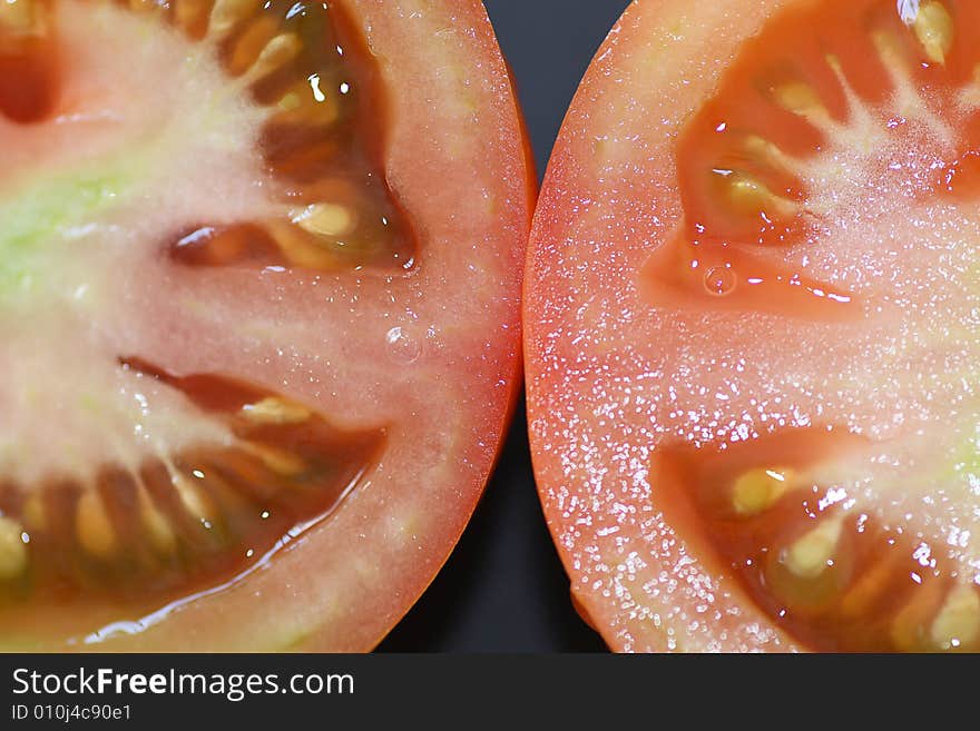 Close up view of a half sliced tomatoe, showing it's seeds. Close up view of a half sliced tomatoe, showing it's seeds.