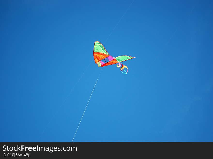 Chinese kite in park with blue sky as background. Chinese kite in park with blue sky as background.