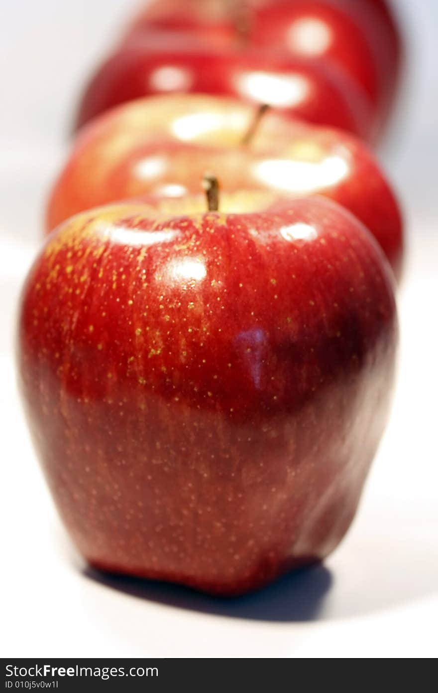 Bunch of red apples on a row isolated on a white background.