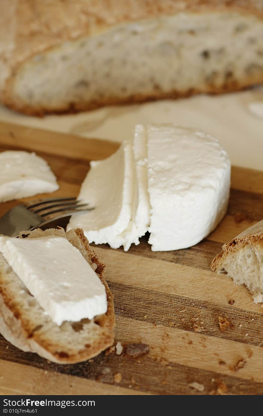 Portuguese, fresh and traditional cheese and bread sliced on a table. Portuguese, fresh and traditional cheese and bread sliced on a table.