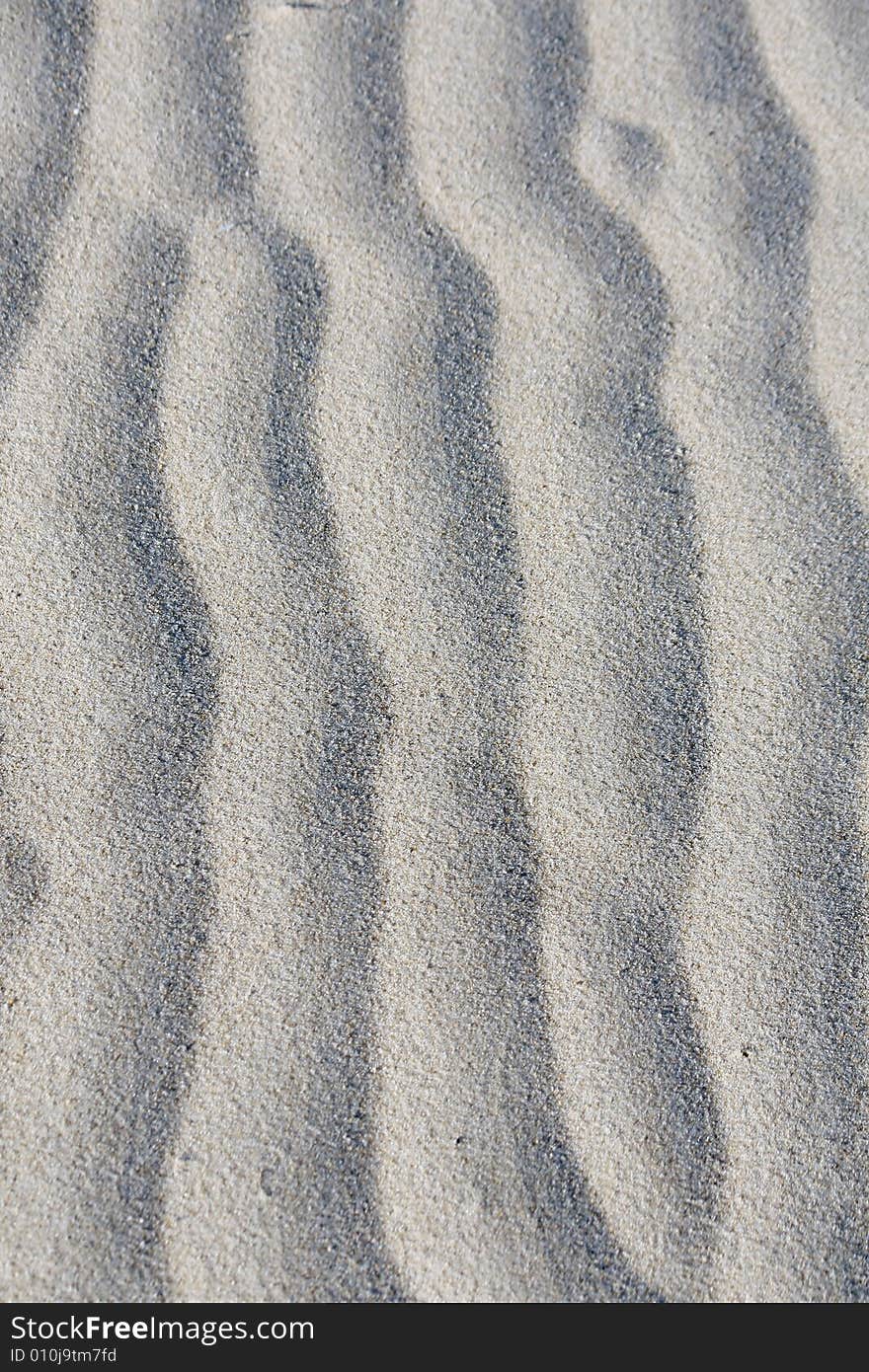 Sand waves formed by wind and the low tide at the beach.