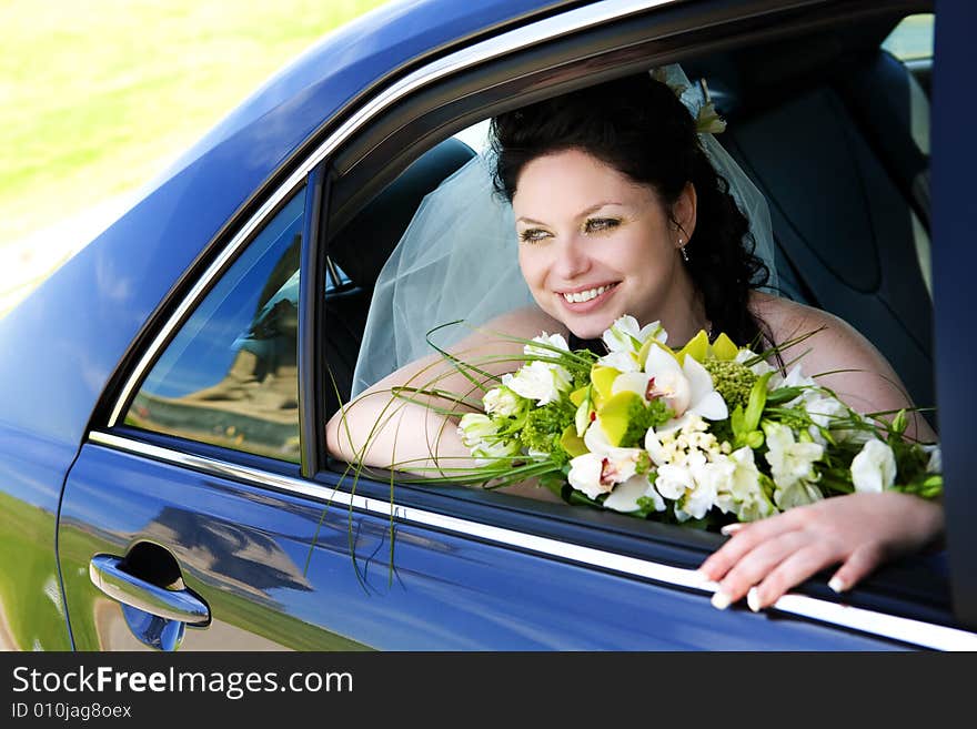 Happy bride with flower bouquet siting in the car. Happy bride with flower bouquet siting in the car