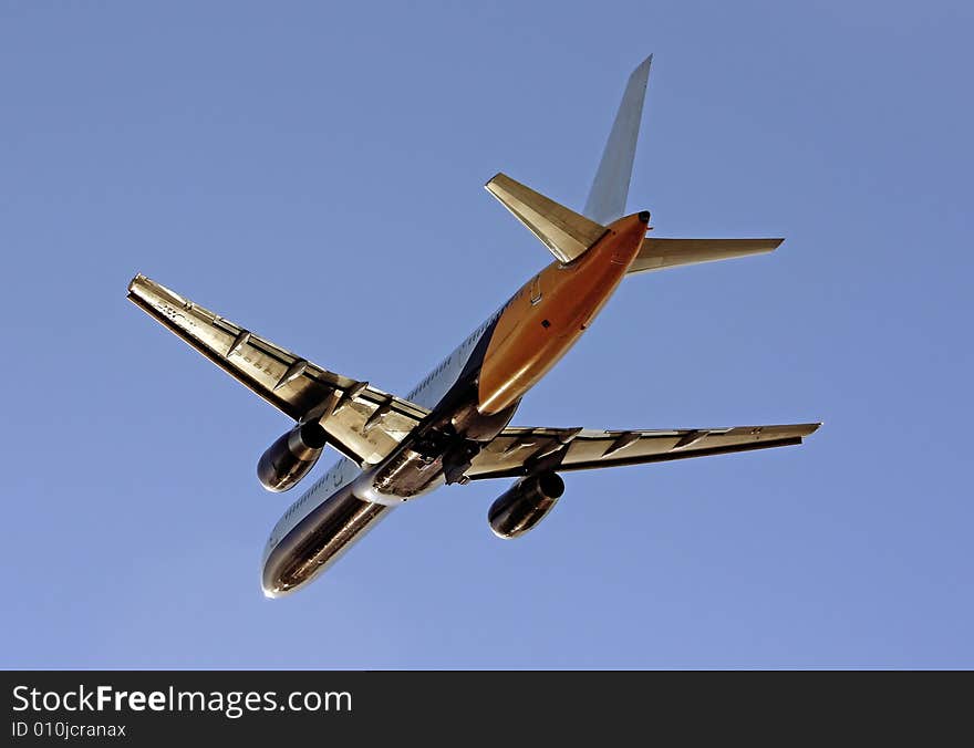 View of a commercial plane departing from the airport, isolated on a blue sky. View of a commercial plane departing from the airport, isolated on a blue sky