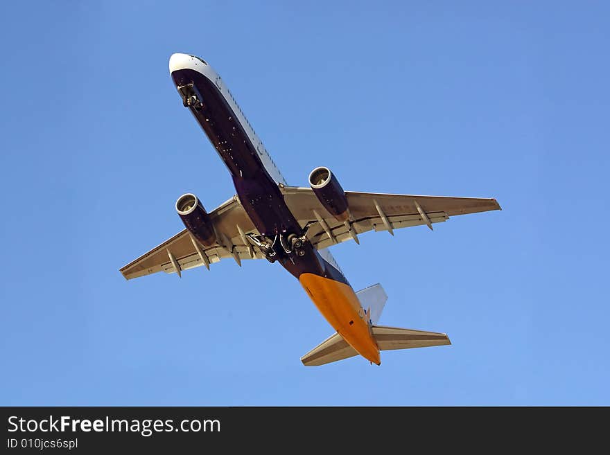 Full view of below of a commercial plane in flight.