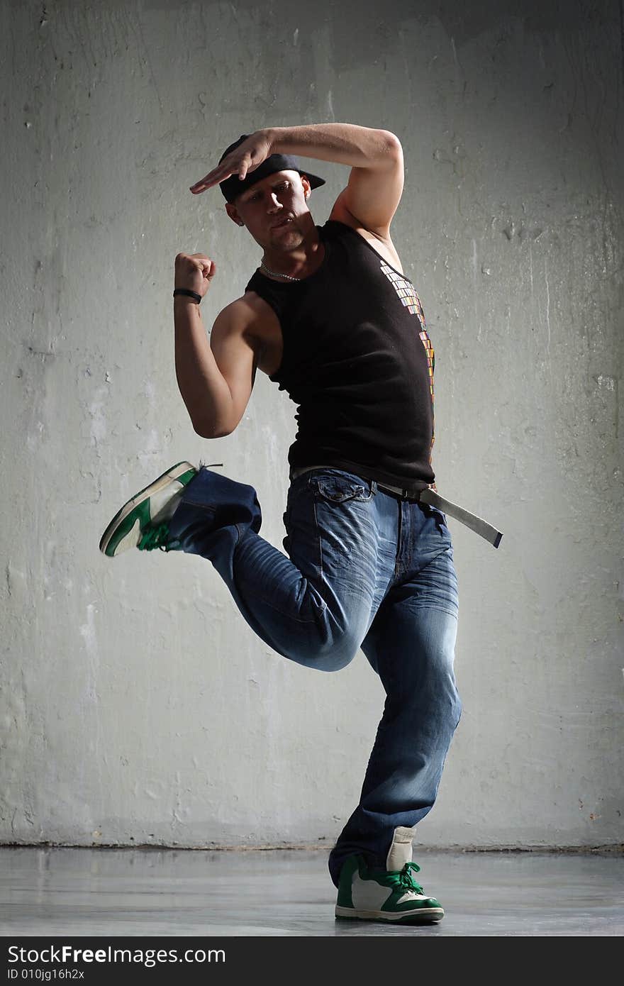 Cool looking dancer posing on old wall