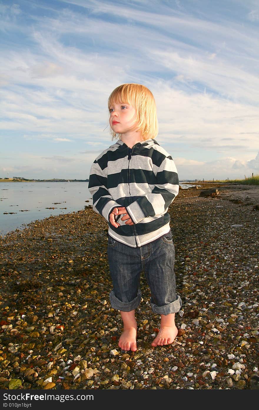 Child on beach looking out over the sea. Child on beach looking out over the sea