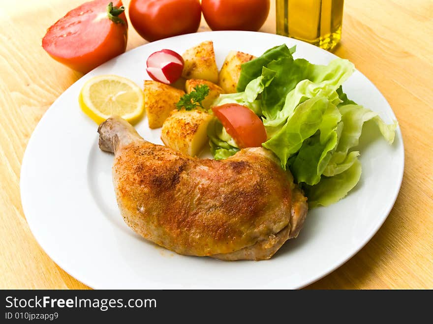 Fried chicken with fried potatoes,lettuce and tomato,radish