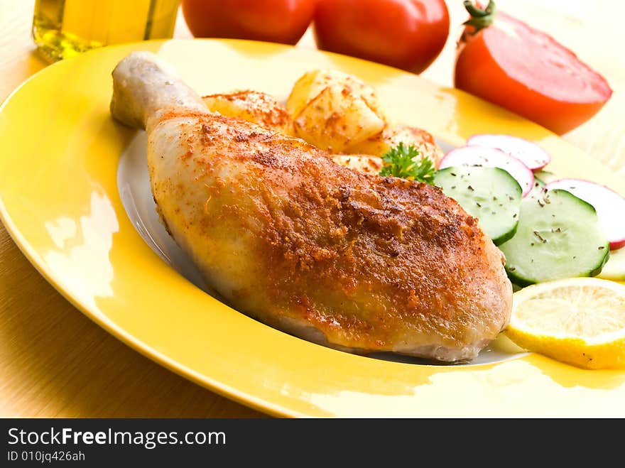 Fried chicken with fried potatoes, and cucumber,tomato,radish.