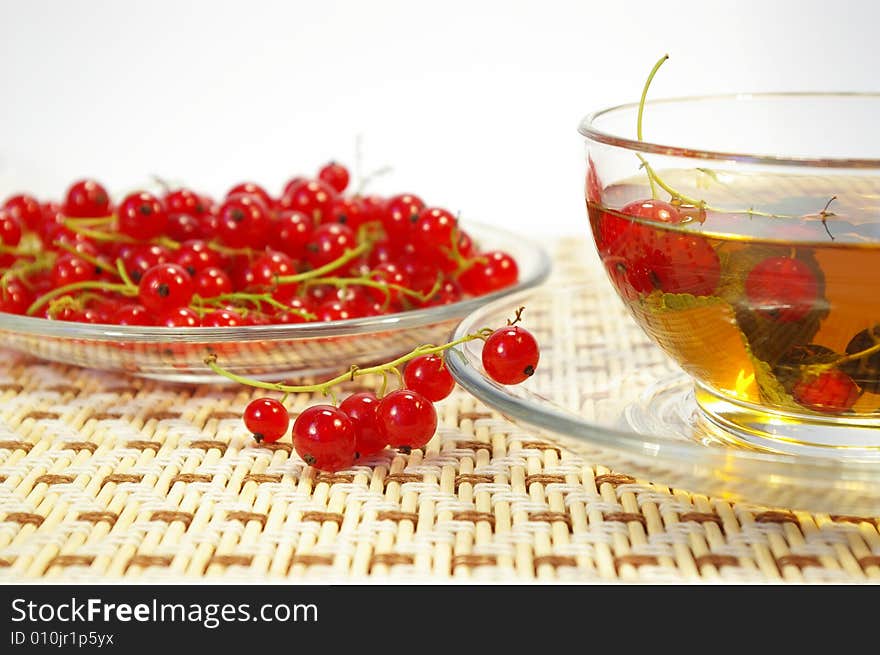 Red currant and herbal tea in a transparent cup. Red currant and herbal tea in a transparent cup