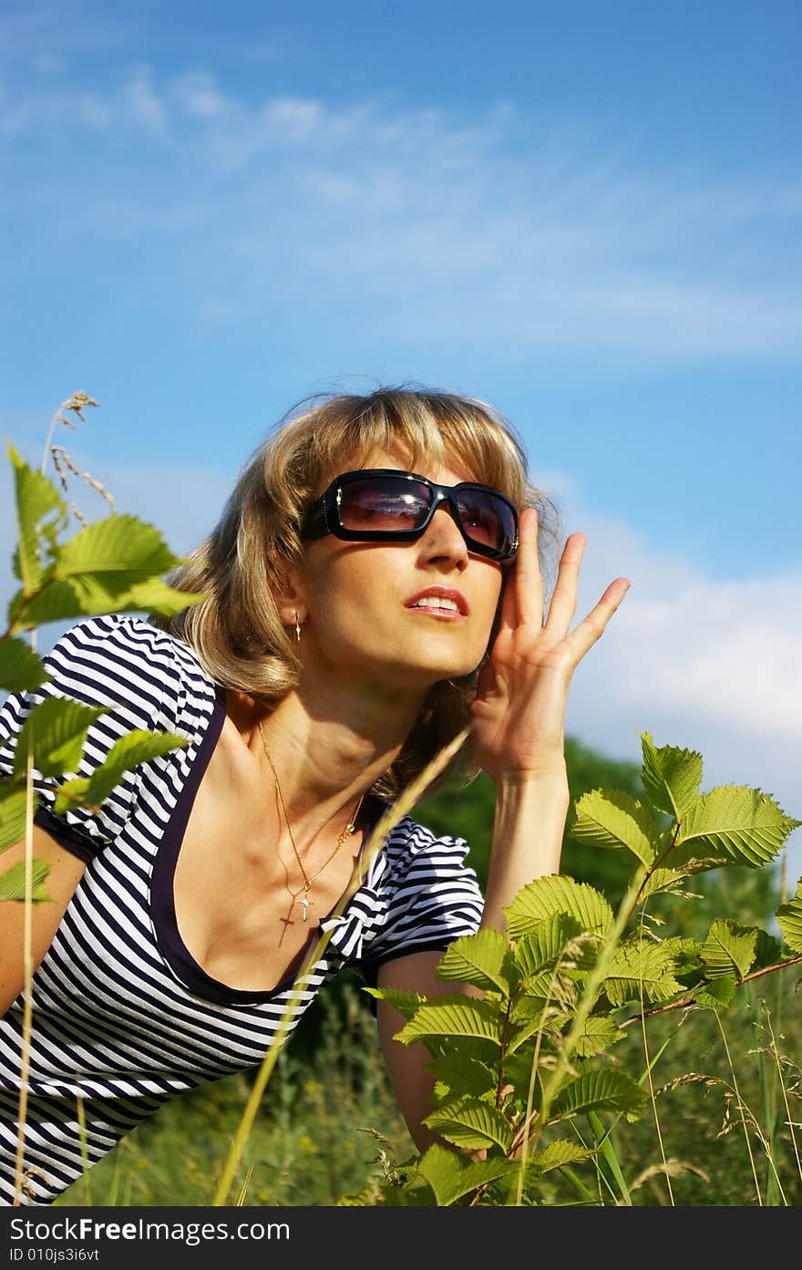 The beautiful woman in sunglasses on a glade. The beautiful woman in sunglasses on a glade