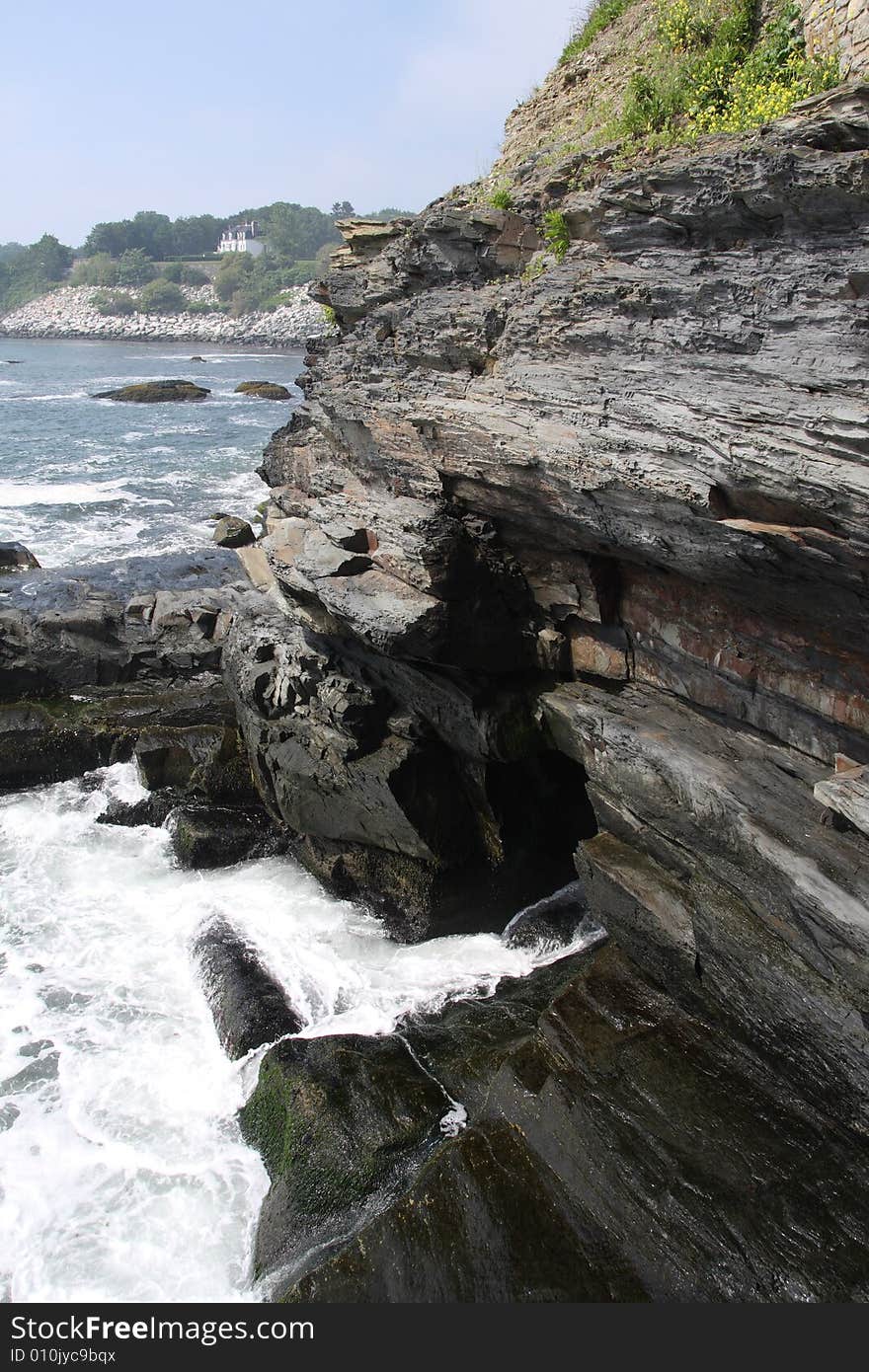 Waves crashing on a rocky shore, cliff and cave