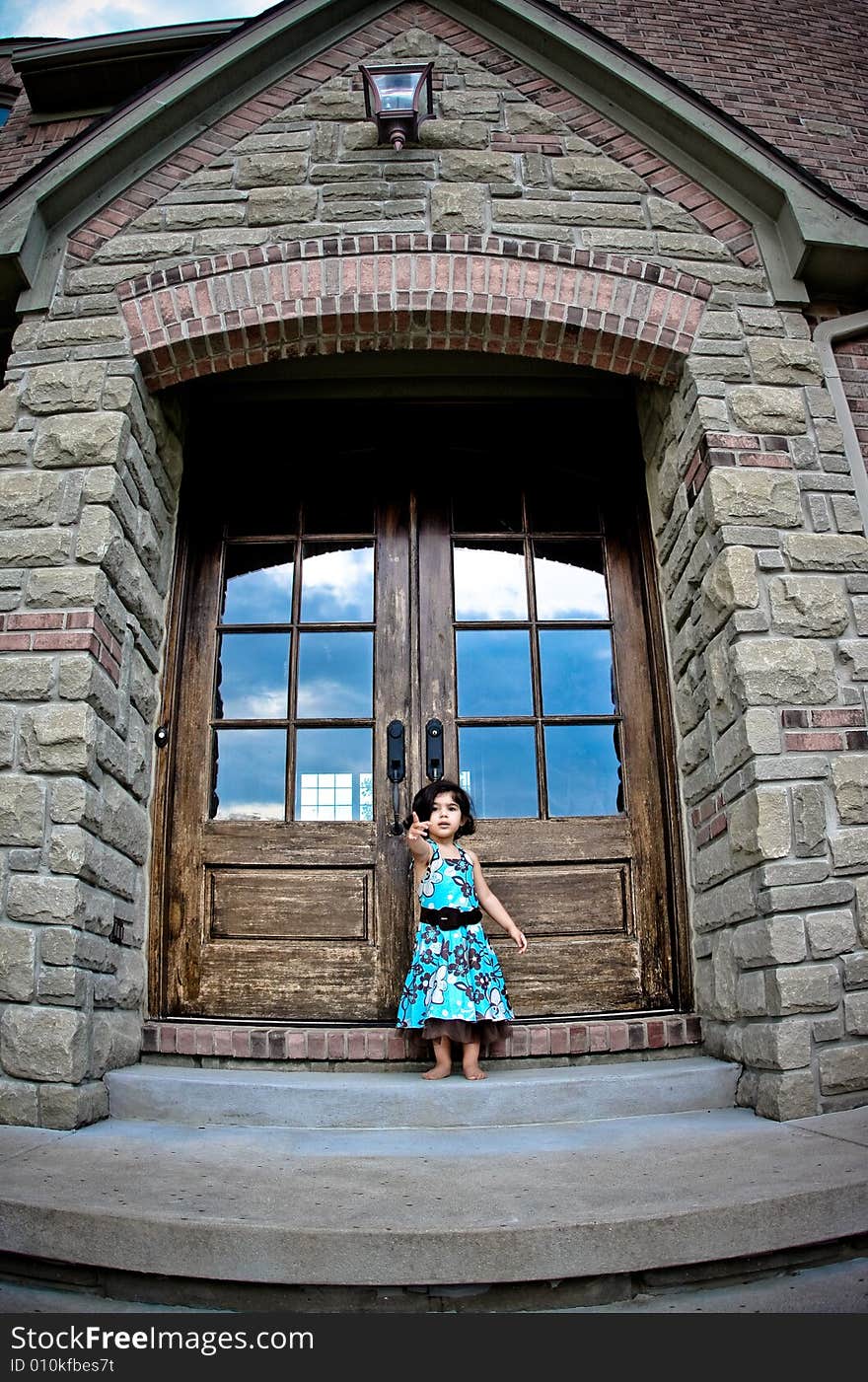 Child standing by an antique door tyring to open it. Child standing by an antique door tyring to open it