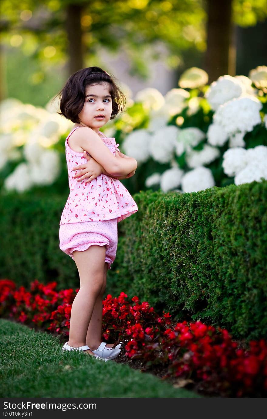 Cute girl in a flower garden smelling flowers. Cute girl in a flower garden smelling flowers