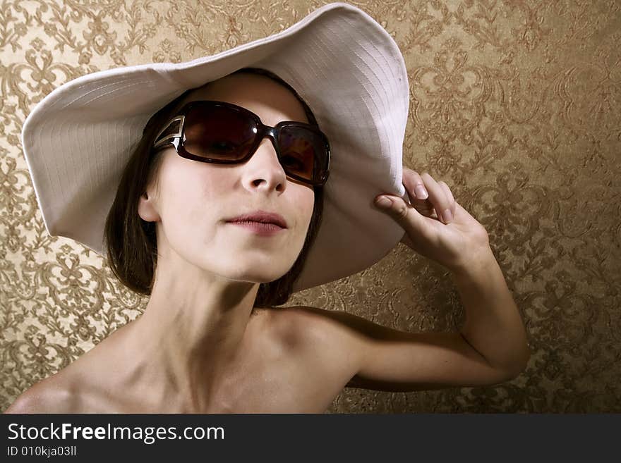 Young Woman with Sunglasses and a Floppy White Hat