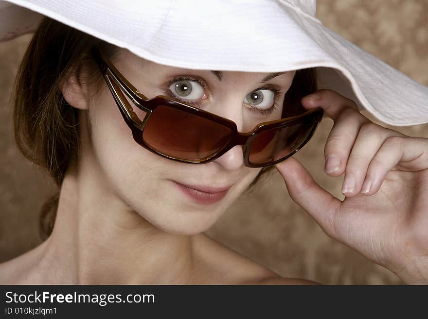 Young Woman with Sunglasses and a Floppy White Hat