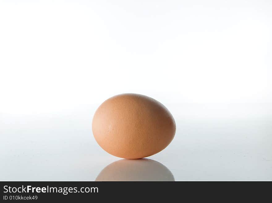 A Brown egg on a white background depicting the idea of youth and maternity