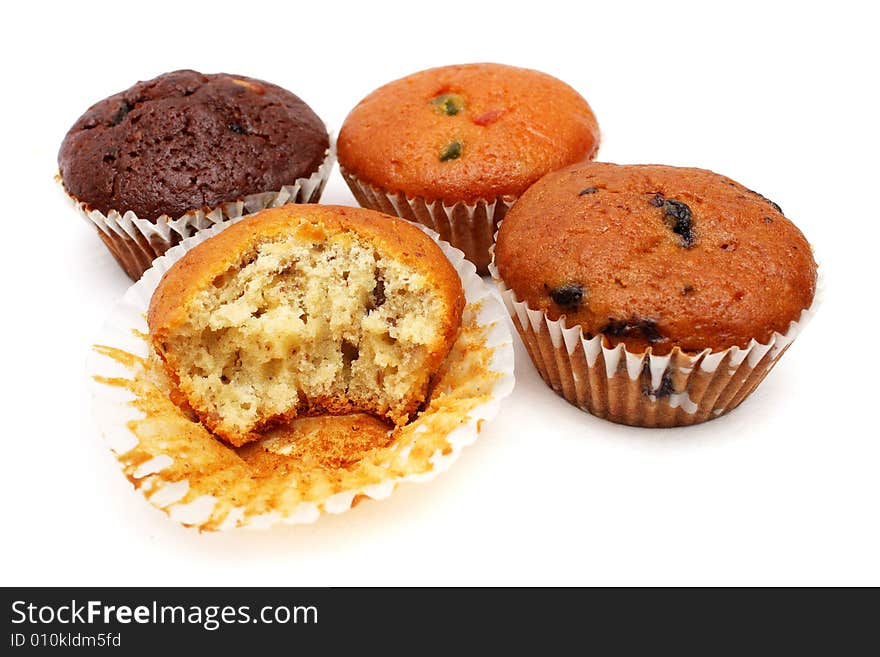 Four different flavor muffins put together on white background.