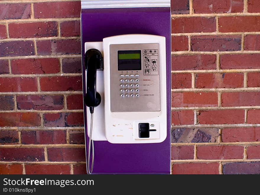 Traditional coin telephone set hanging on red brick wall. Traditional coin telephone set hanging on red brick wall