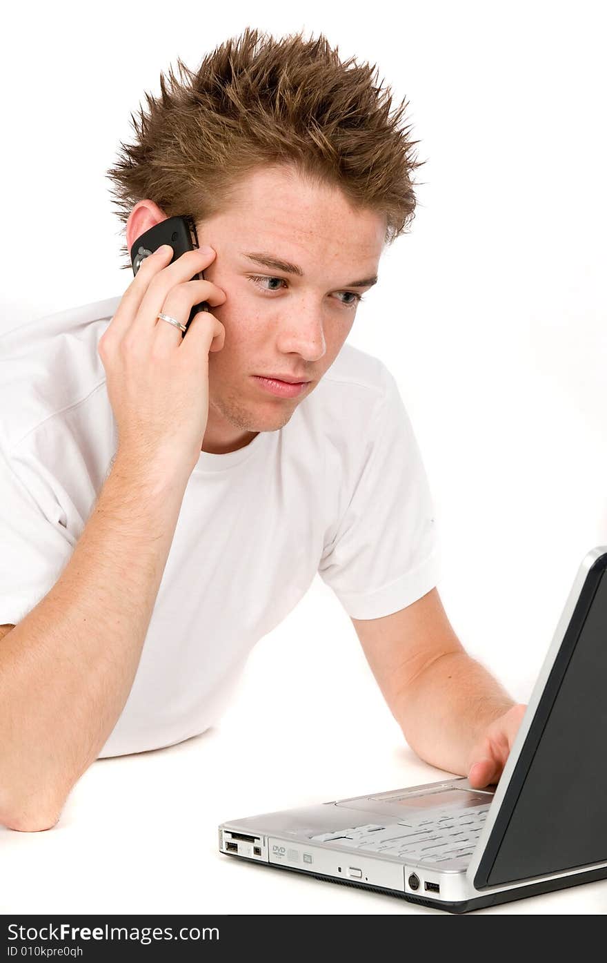 A young man multitasking on the phone and computer