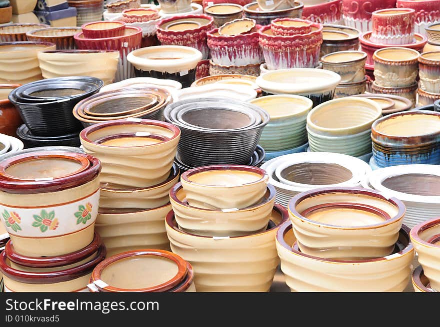 The ceramic plant pots of various shapes and colors in a market. The ceramic plant pots of various shapes and colors in a market.