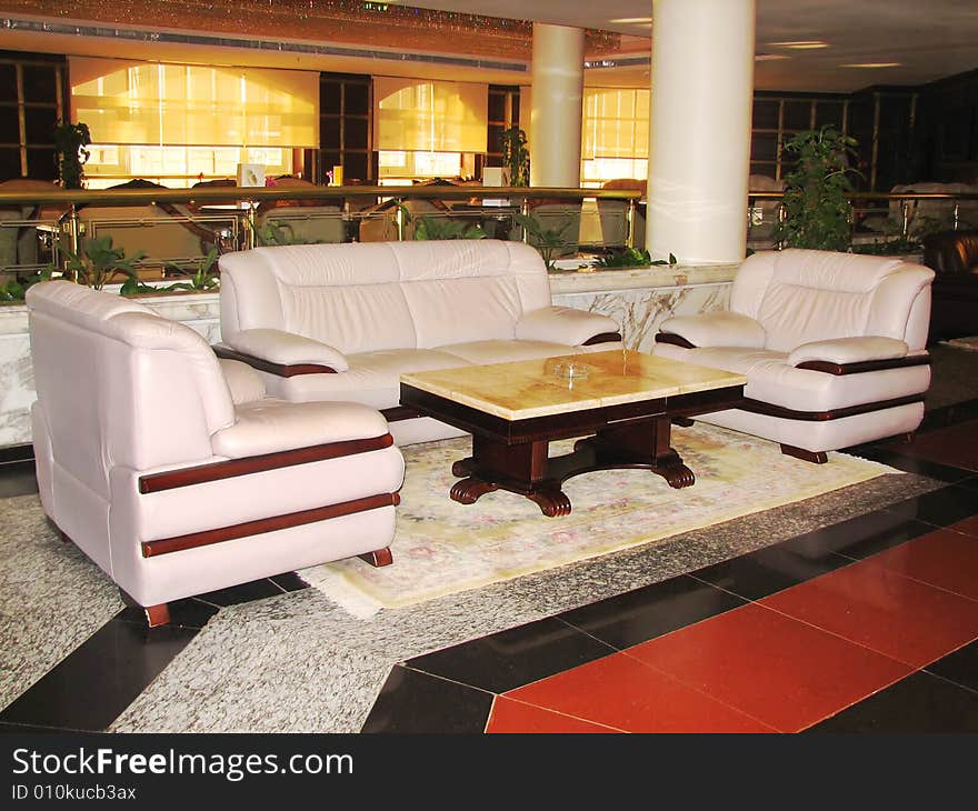 Sofa and armchairs with table in hall of hotel