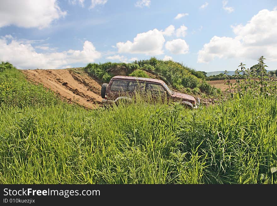 A 4x4 vehicle driving through rough hilly ground. A 4x4 vehicle driving through rough hilly ground