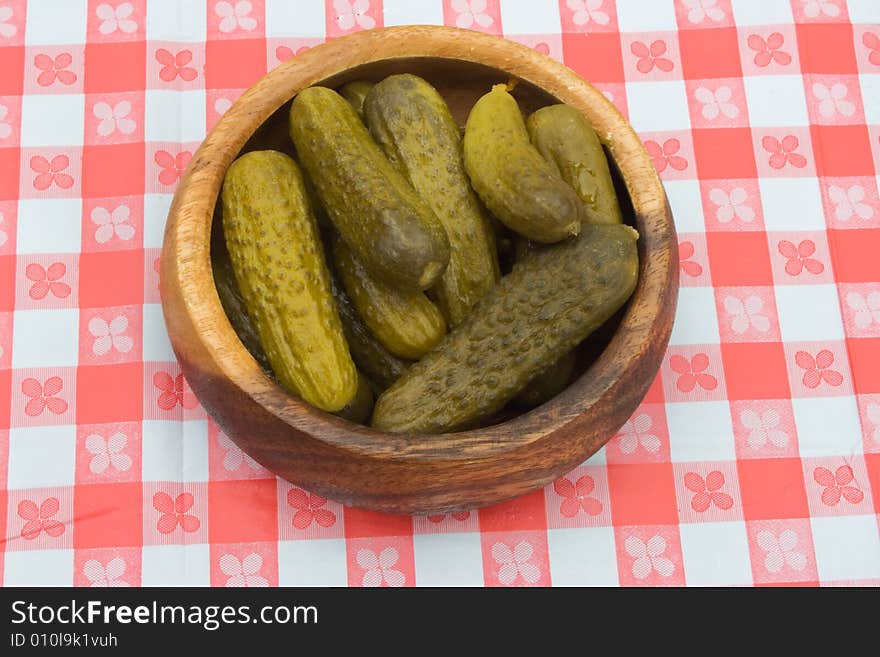 A bowlful of preserved garnish on a table cowered with checkered buckram