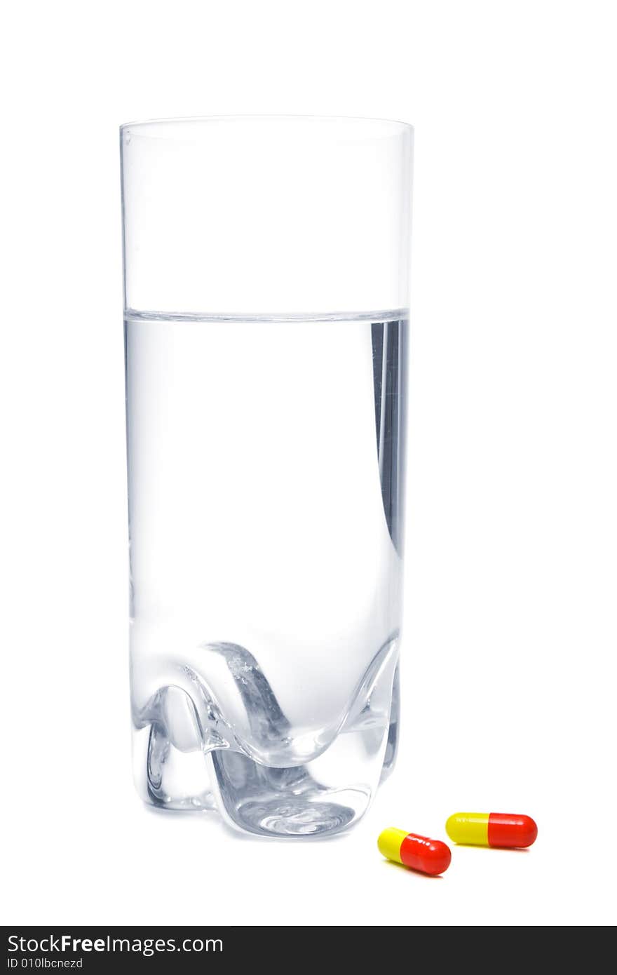 Glass with water and pills, isolated, on white background